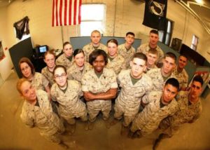 Sgt. Tanell Nedd, (center) a tactical switch operator and the Platoon Sergeant for the S-6 Communications shop with Combat Logistics Battalion 2, 2nd Marine Logistics Group, stands with her Marines in the wire shop of the CLB-2 compound. Nedd was nominated as CLB-2's outstanding woman in honor of Women's History Month.