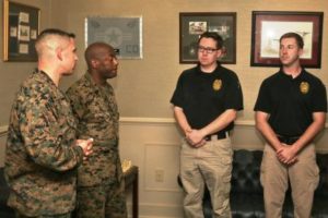 Col. Timothy Miller and Sgt. Maj. Derrick Mays congratulate police officers Sean Sullivan and Peter Bunting aboard Marine Corps Air Station Beaufort Feb. 20. (Photo by Lance Cpl. Terry Haynes)