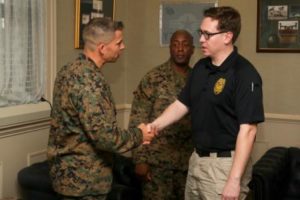 Police Officer Sean Sullivan is awarded a coin by Col. Timothy Miller aboard Marine Corps Air Station Beaufort, Feb. 20. (Photo by Lance Cpl. Terry Haynes)